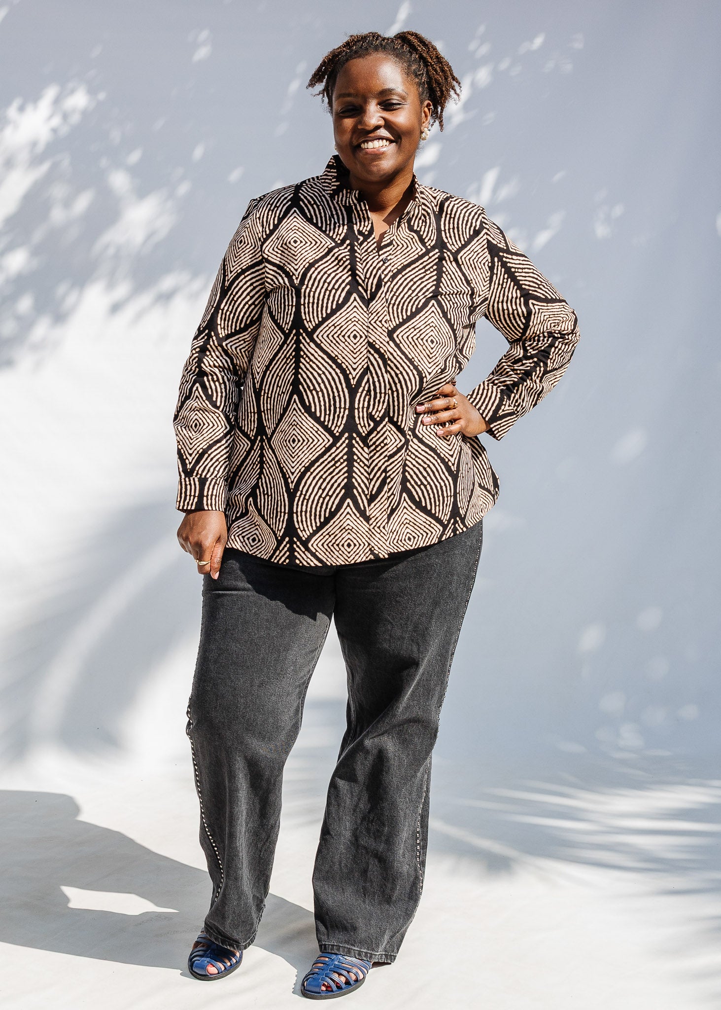 Model wearing black and beige abstract print blouse.