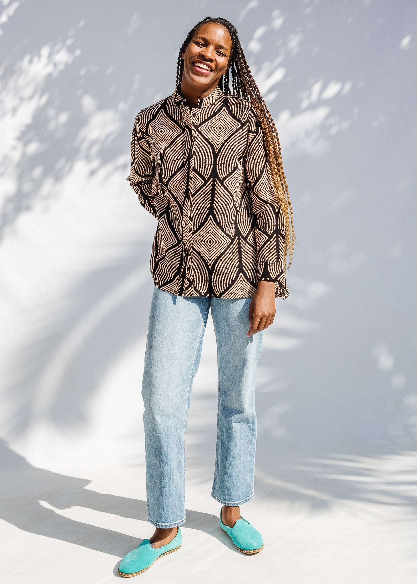 Model wearing black and beige abstract print blouse.