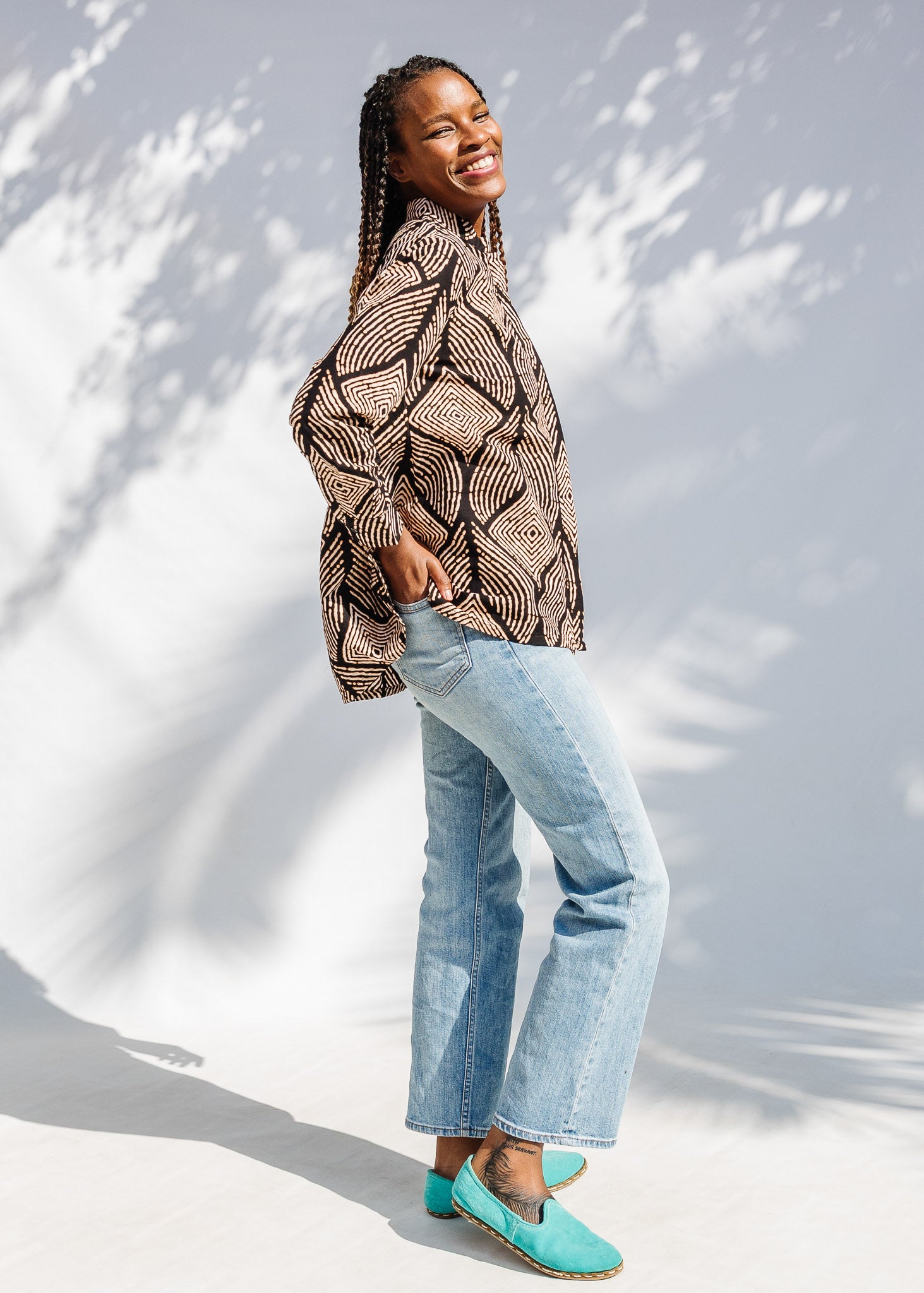 Model wearing black and beige abstract print blouse.