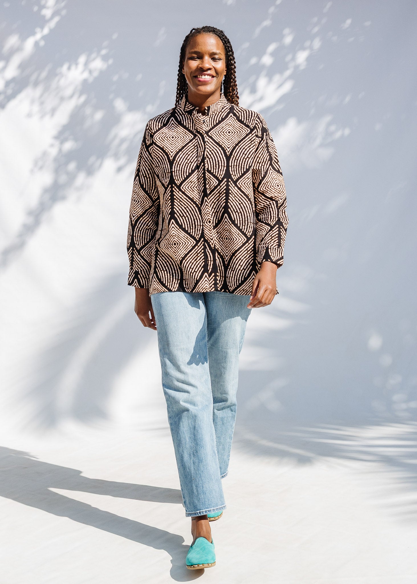 Model wearing black and beige abstract print blouse.