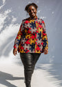 Model wearing multicolored puzzle print shirt.