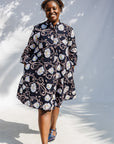 Model wearing black dress with pink and yellow floral print.