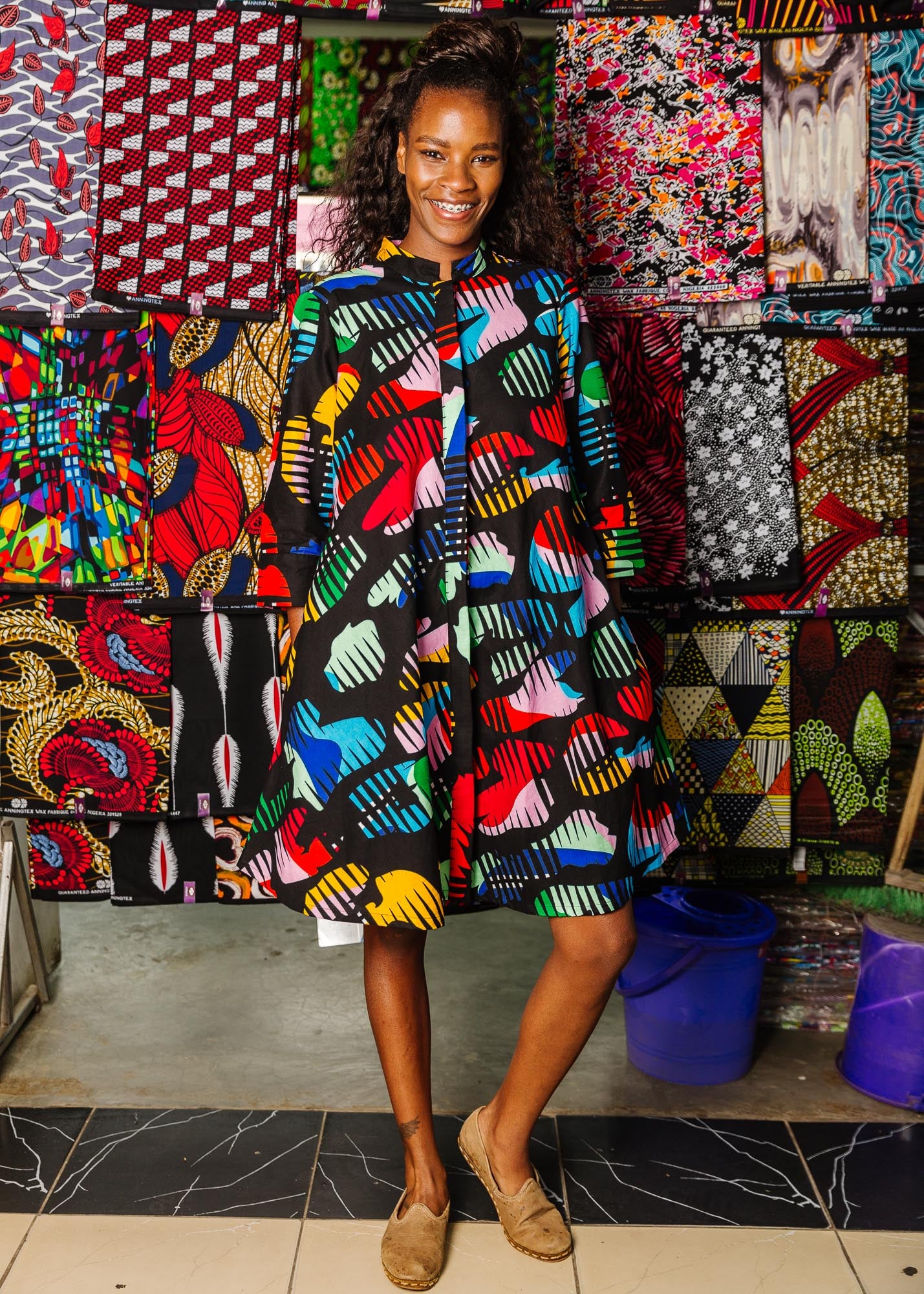 The model is wearing abstract multi-color  figures dress