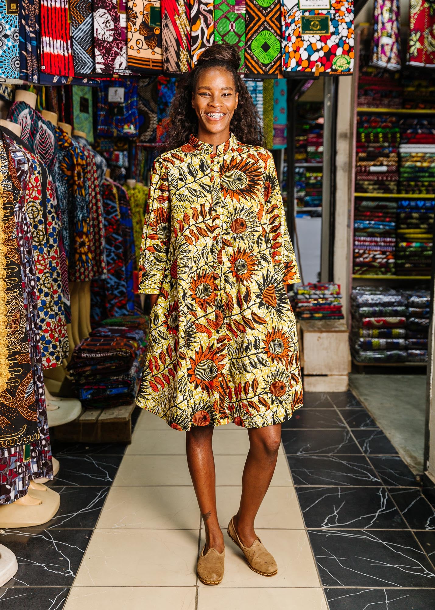 The model is wearing white and chartreuse dress with orange and black sunflowers