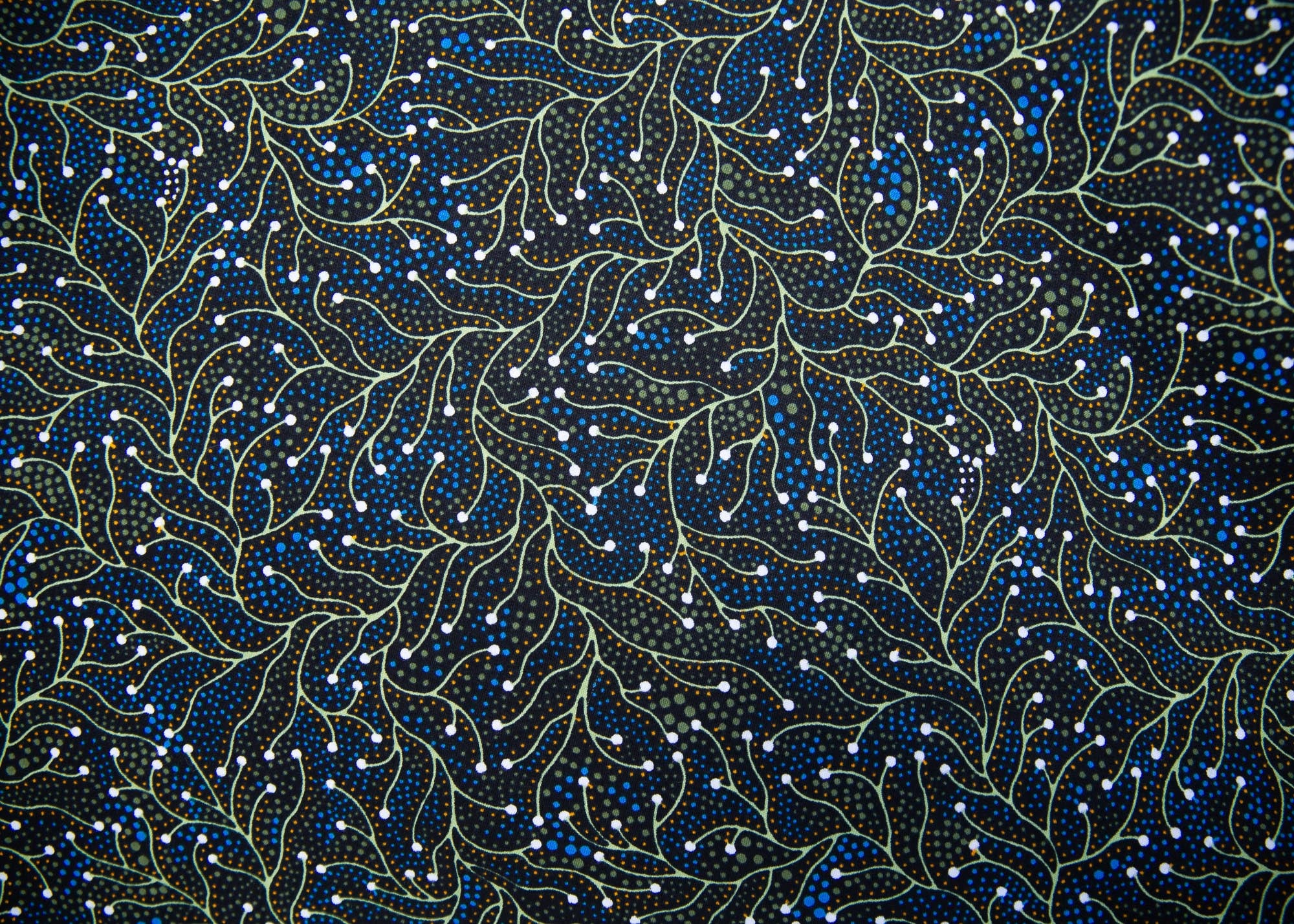 Close up display of blue, white, black , yellow and green vine print dress