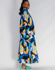 Model wearing blue, black, orange, yellow, orange and white geometric print shirt and culotte.