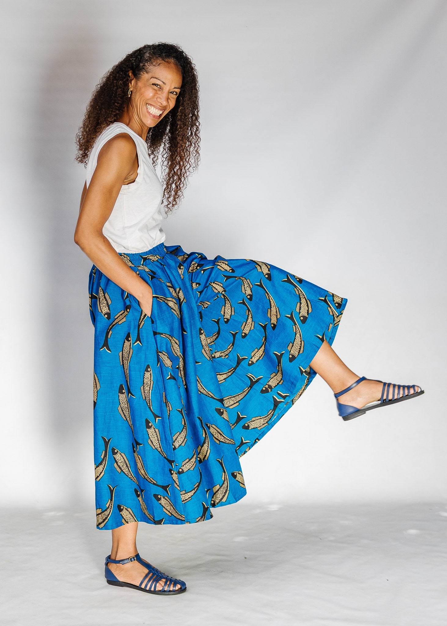 Model wearing white shirt with blue pants with beige fish print.