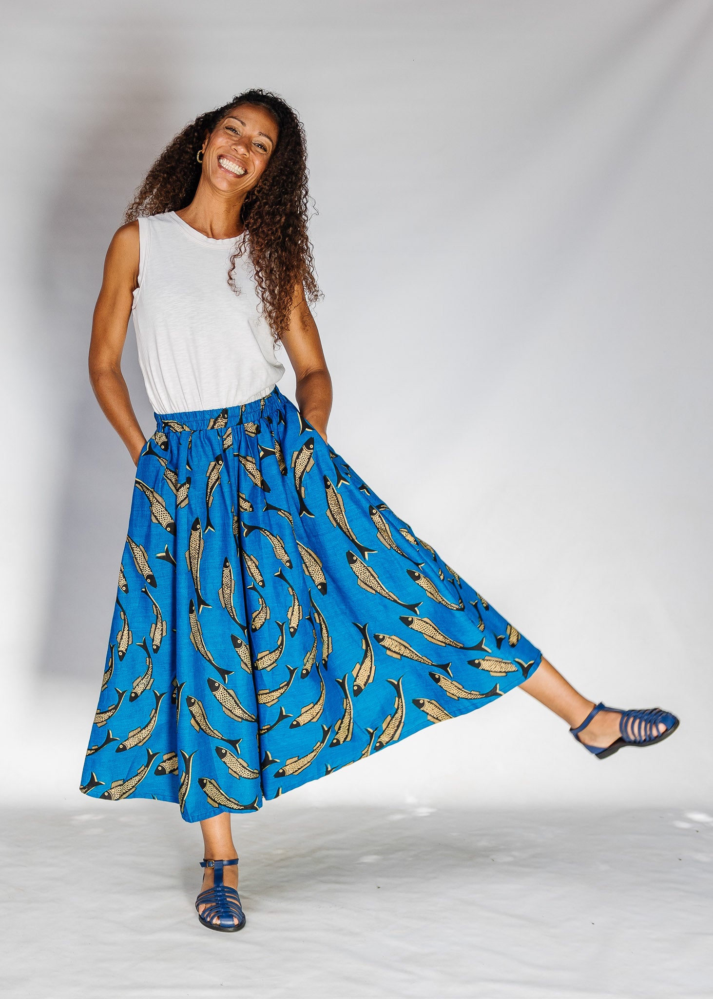 Model wearing white shirt with blue pants with beige fish print.