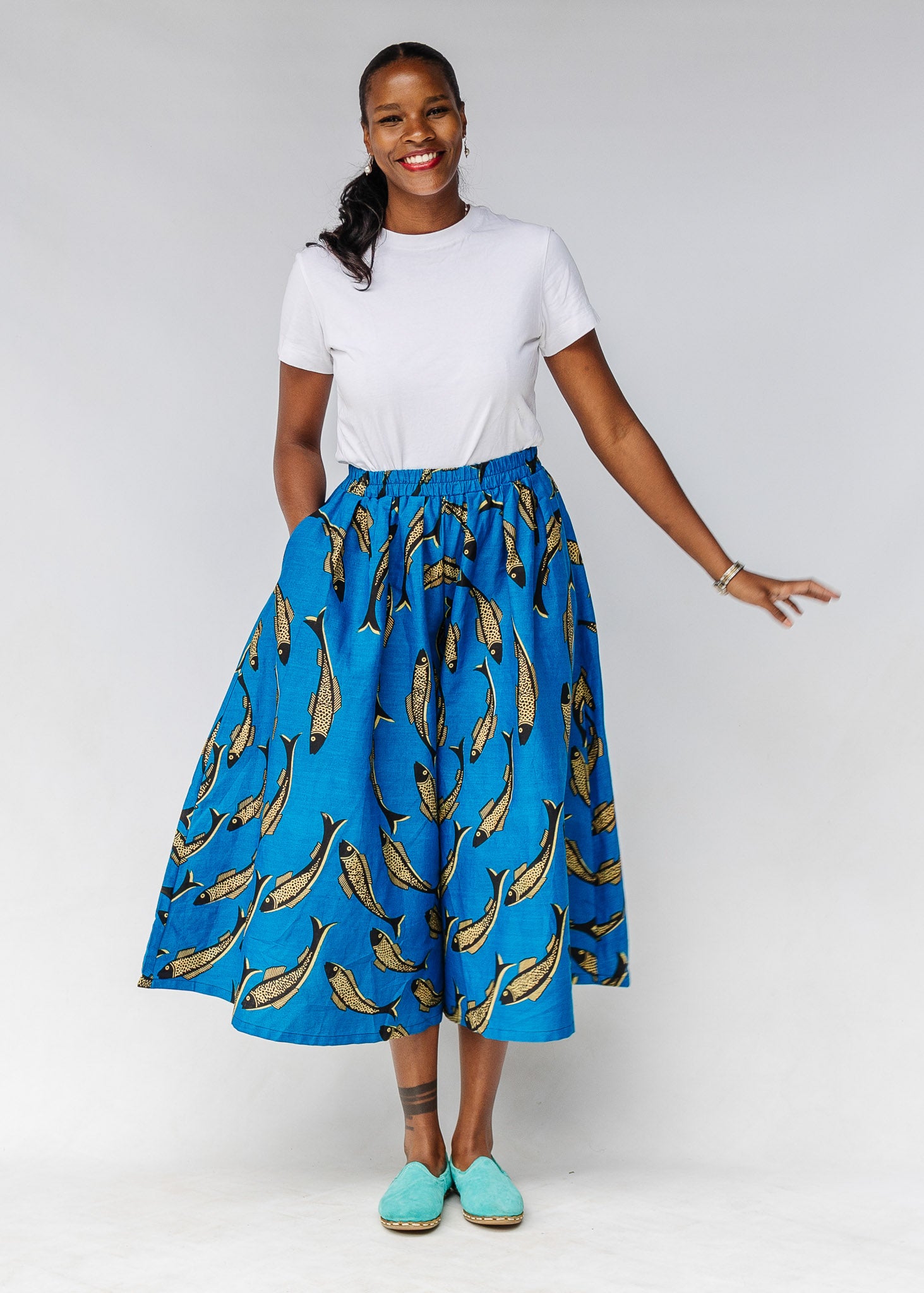 Model white shirt with blue pants with beige fish print.