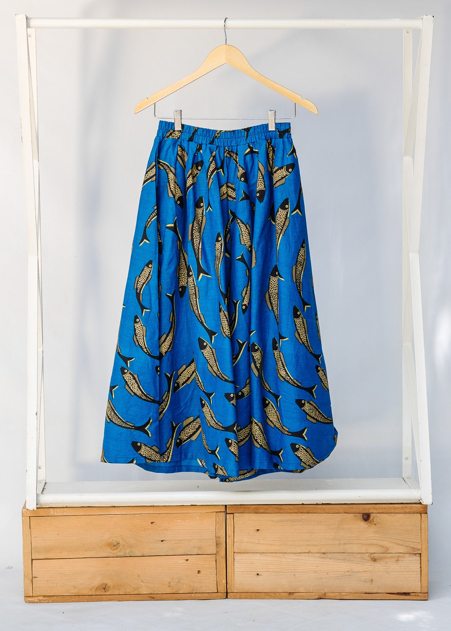 Display of blue pants with beige fish print.
