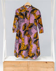 Display of pink dress with orange and black fan print.