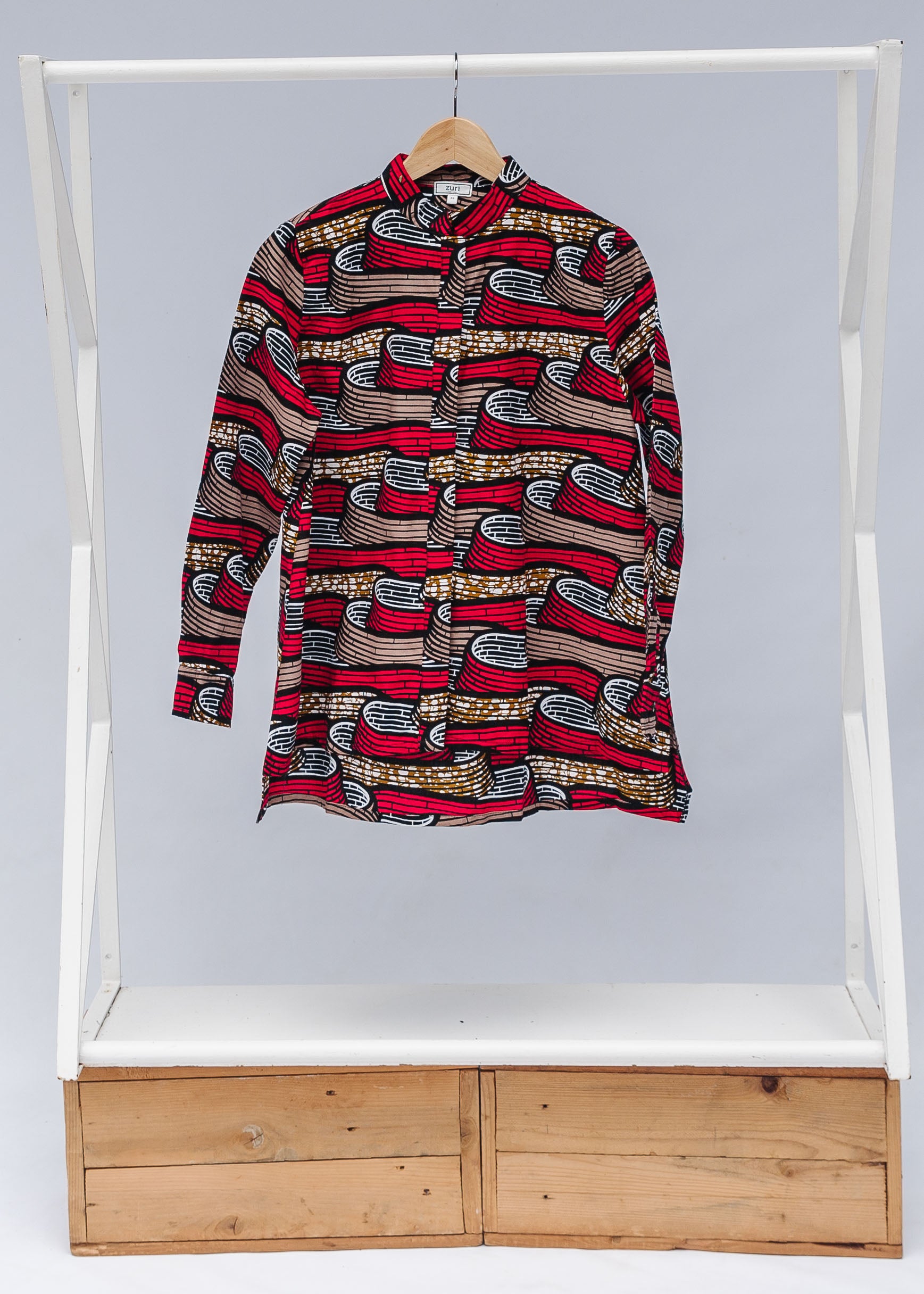 Display of a red, brown and black scroll printed long sleeve blouse.