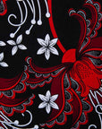 Display of black dress with red and white flowers, fabric.