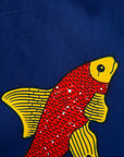 Close up display of navy sleeveless dress with red and yellow fish print.