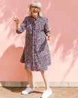 Model wearing blue and red ribbon print dress.