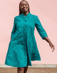Model wearing turquoise dress with small black vine print.