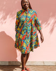 Model wearing colorful rainbow leaves print dress.