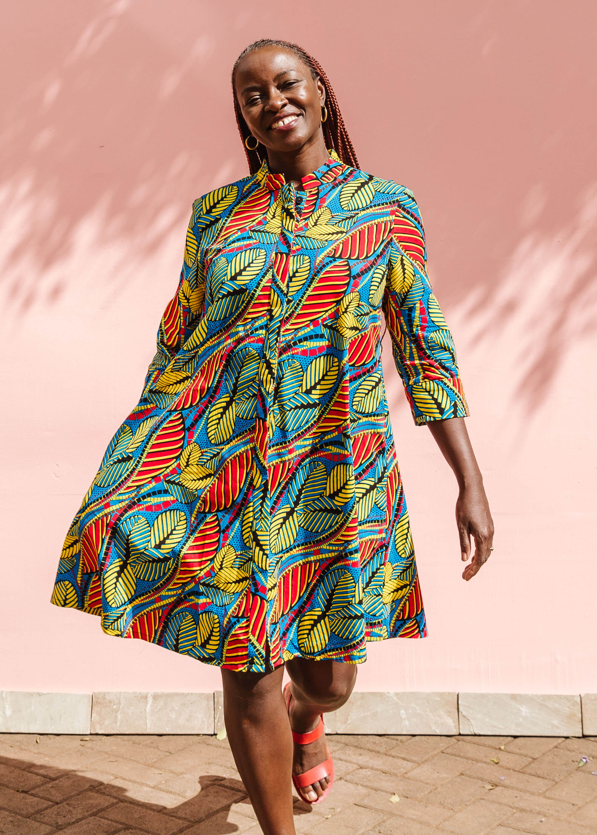 Model wearing colorful rainbow leaves print dress.