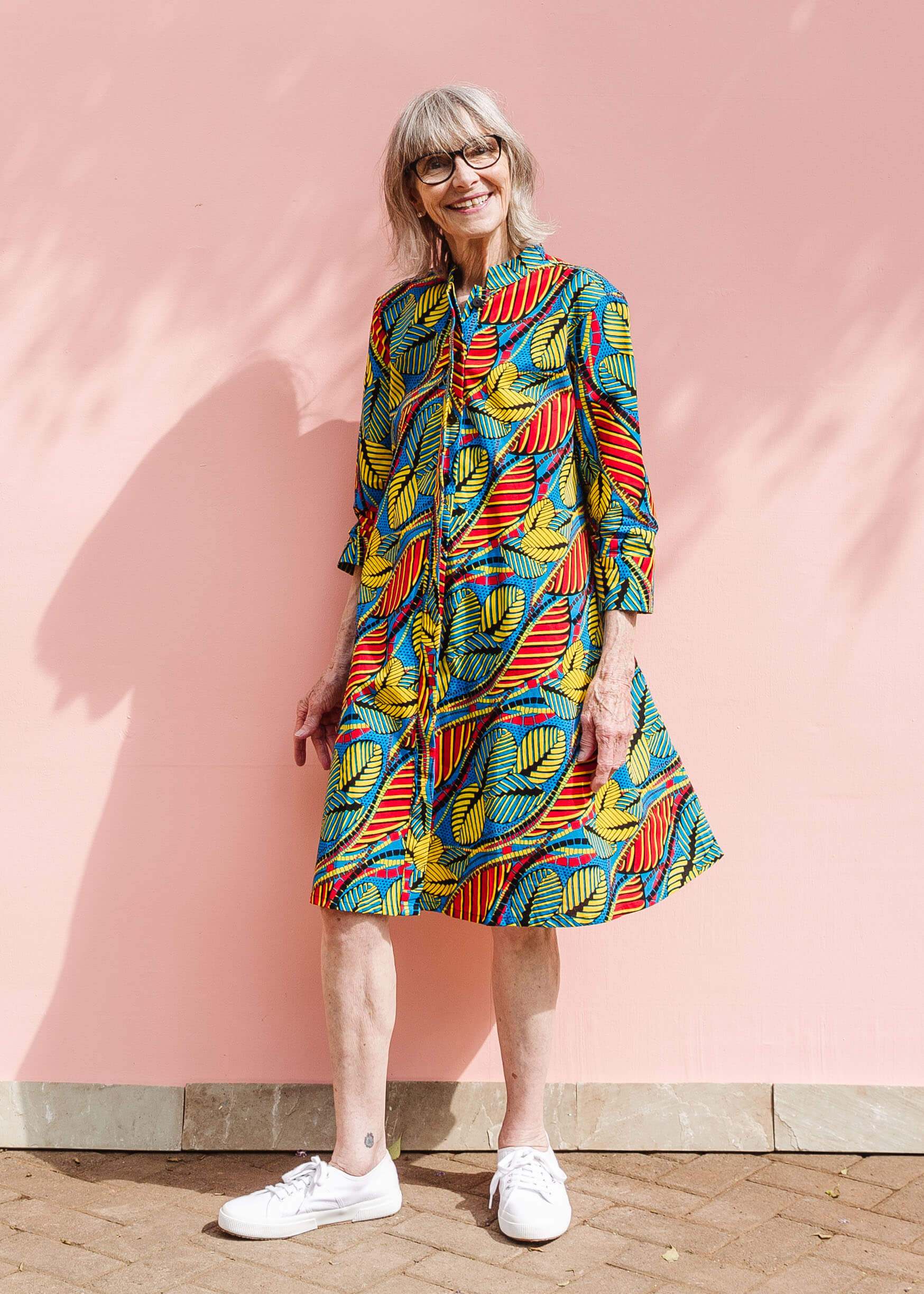 Model wearing colorful rainbow leaves print dress.