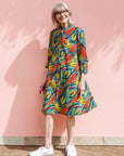 Model wearing colorful rainbow leaves print dress.