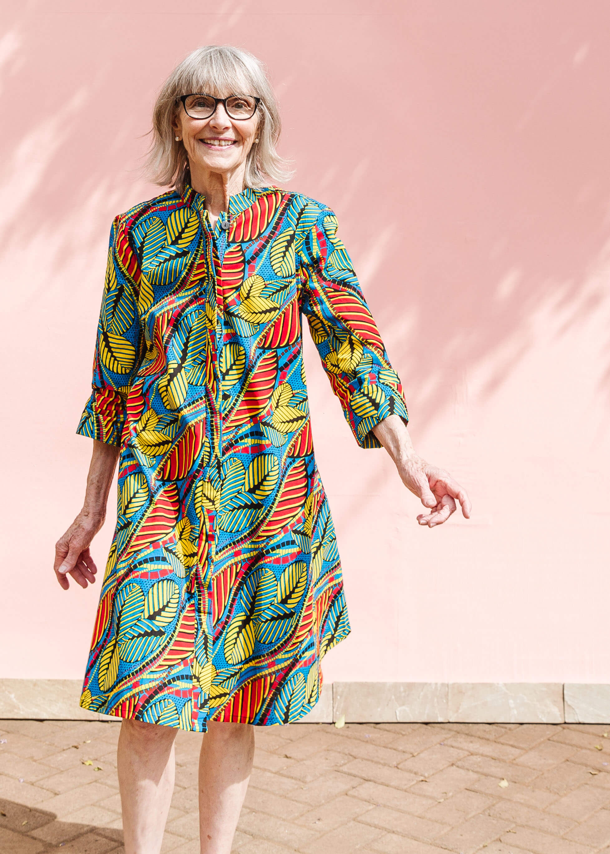 Model wearing colorful rainbow leaves print dress.