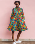 Model wearing colorful rainbow leaves print dress.