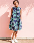 Model wearing blue, white, and green, geometric print dress.