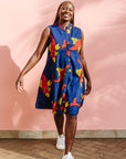 Model wearing navy sleeveless dress with red and yellow fish print.