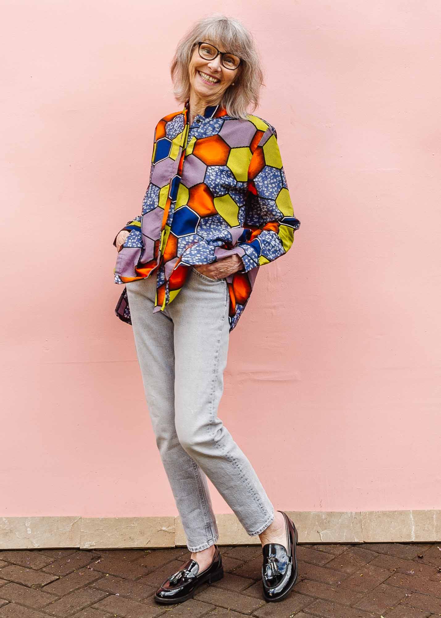 The model is wearing multicolored long sleeved shirt with geometric print 