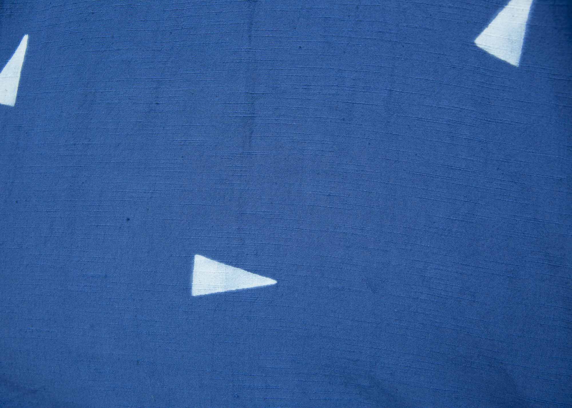 Close up display of blue sold dress with white triangles
