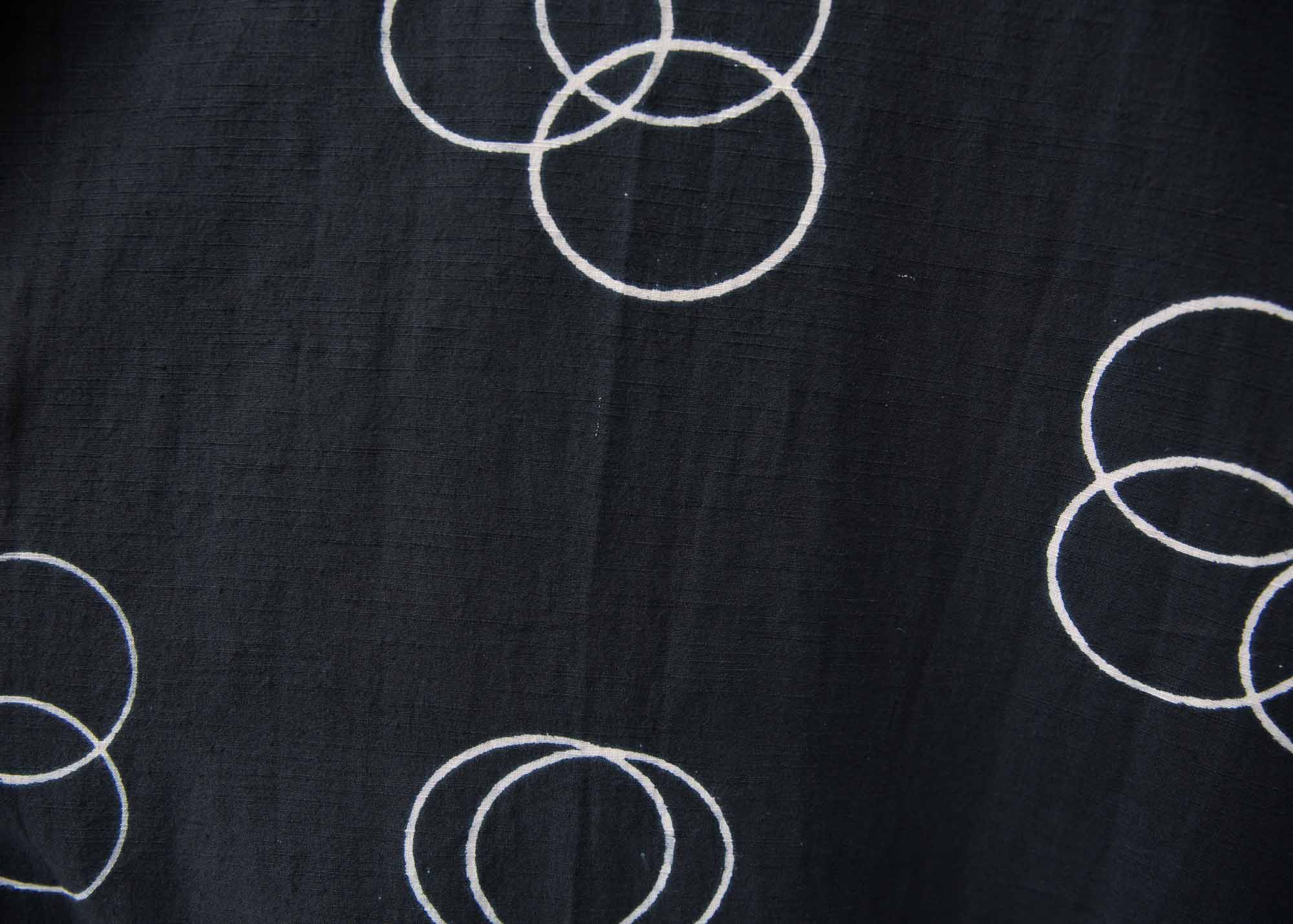Close up of solid black dress with white circular print, fabric