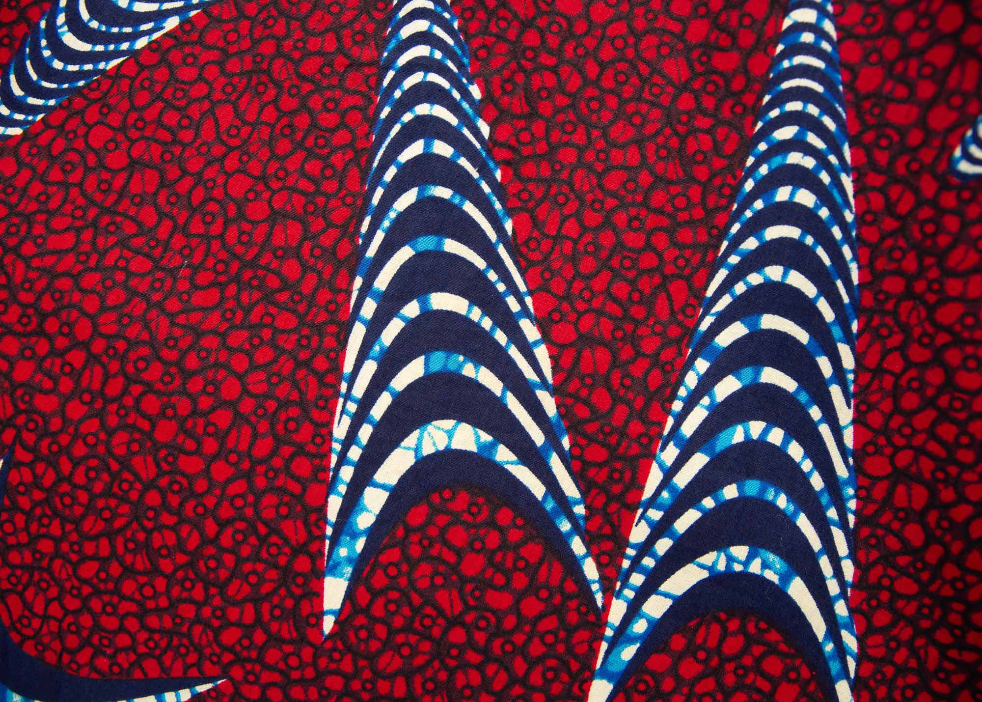 Close up display of red and black dress with navy blue and beige print