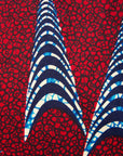 Close up display of red and black dress with navy blue and beige print