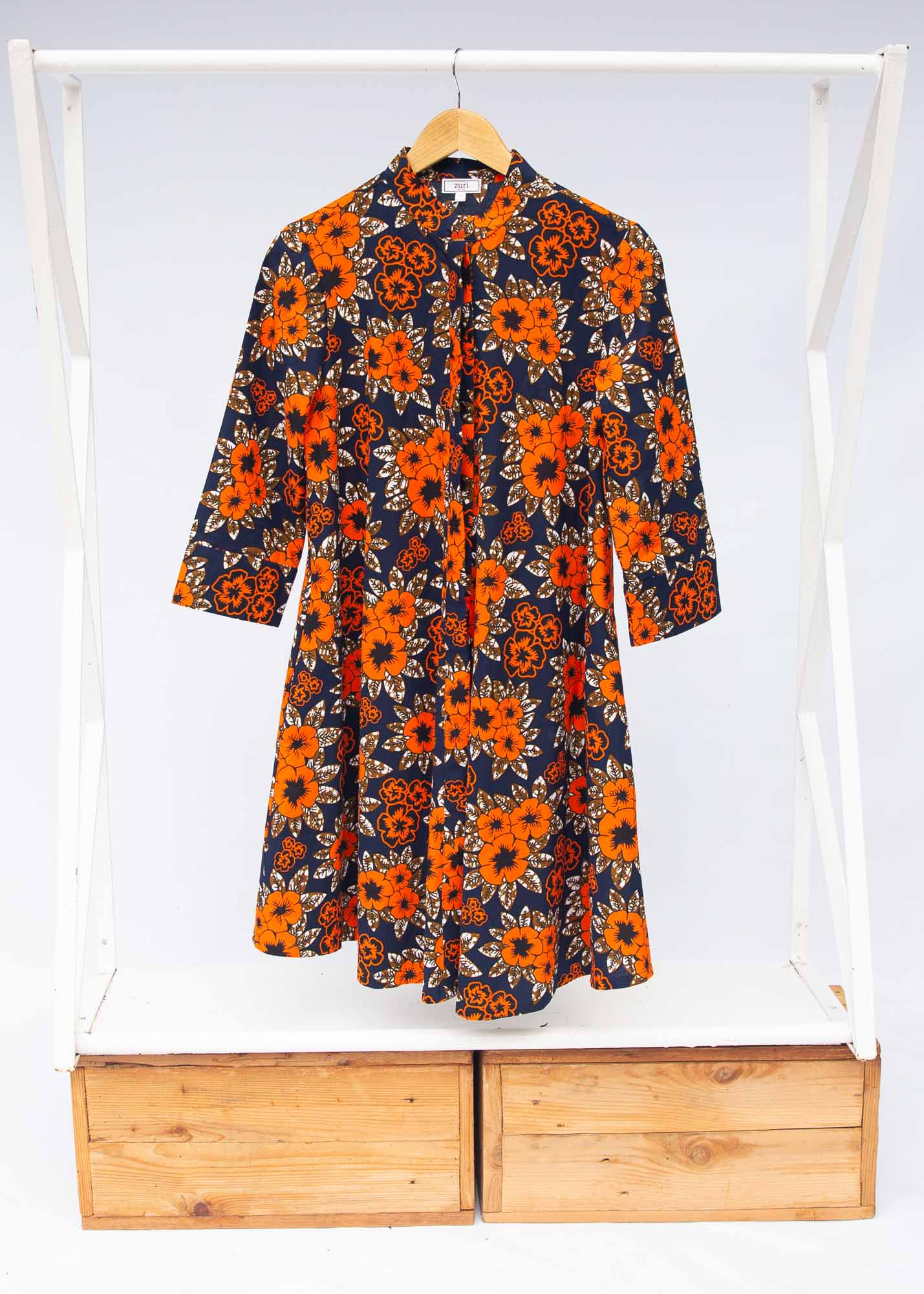 The display of navy dress with orange, brown, black and white floral print