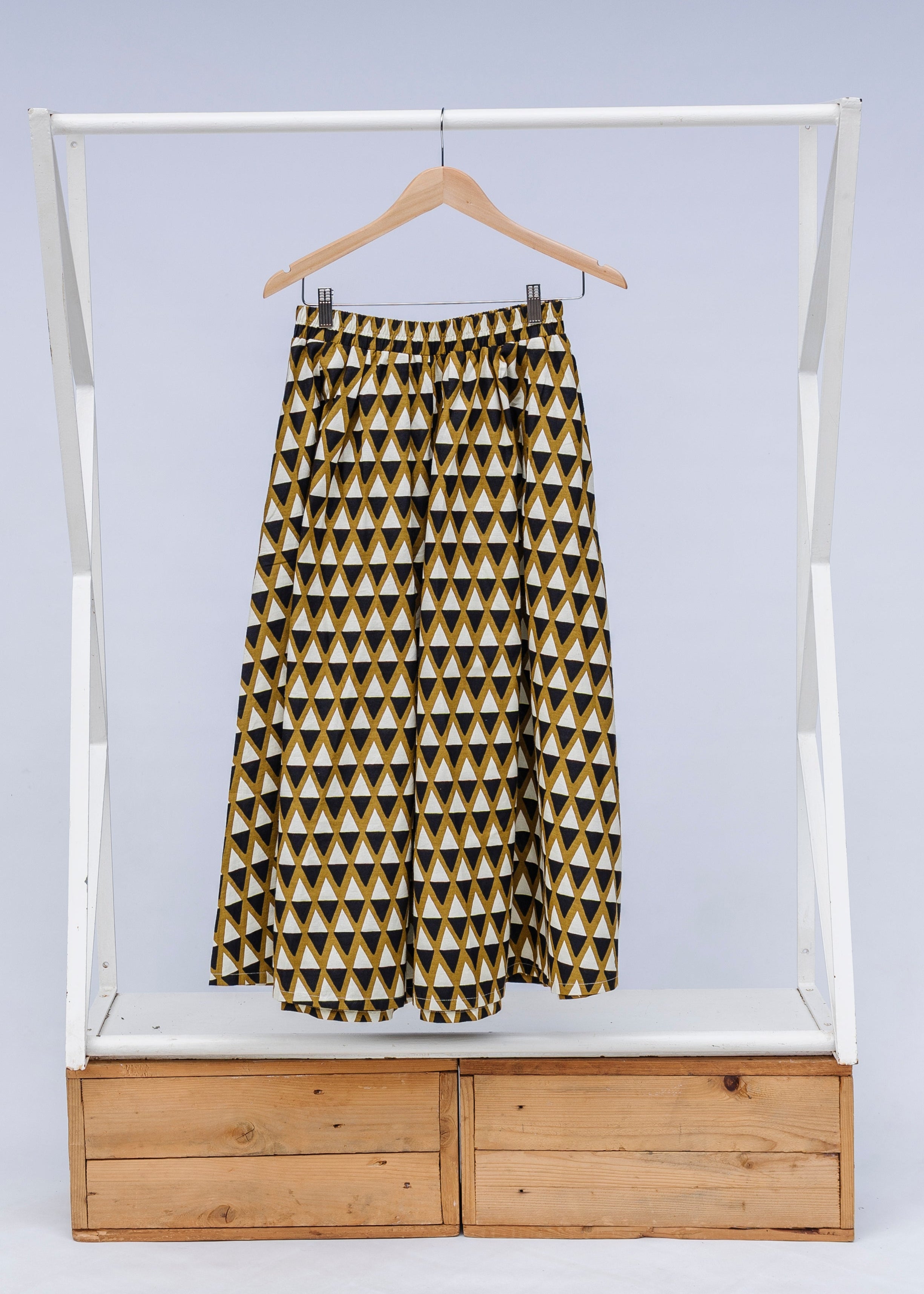 Display of mustard and black triangle print pants.