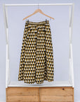 Display of mustard and black triangle print pants.