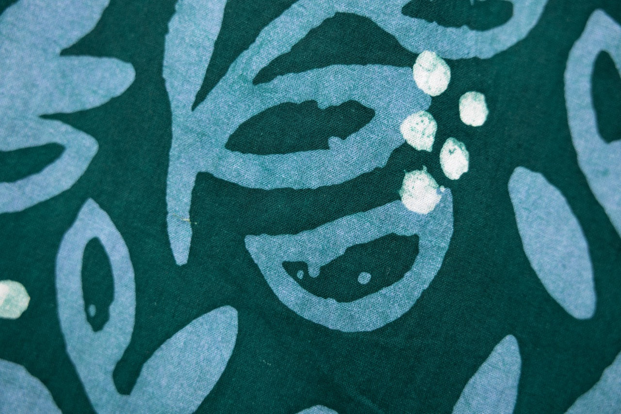 Close up display of green and blue floral batik dress, fabric