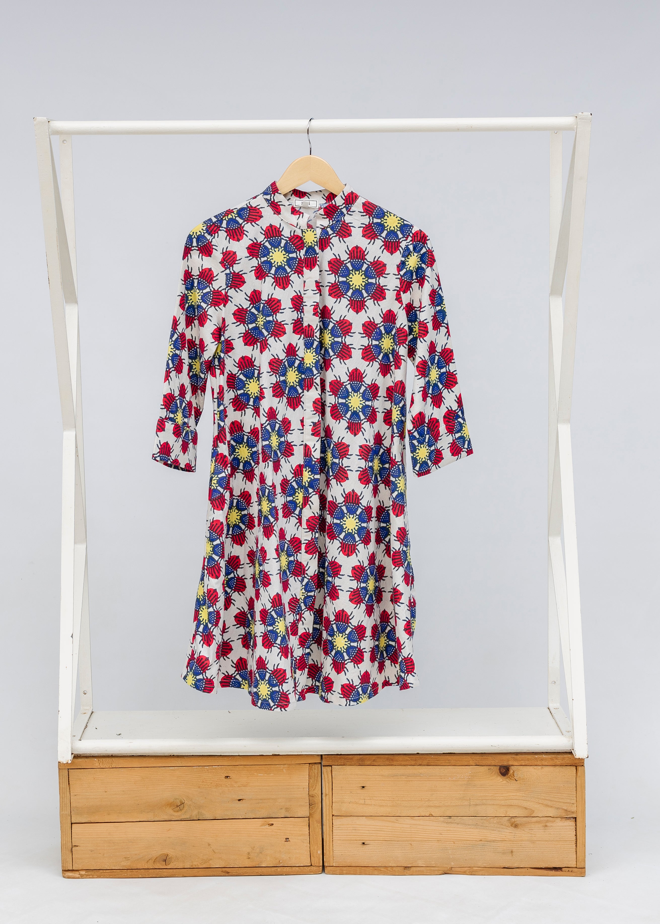 Display of dress with yellow, red and blue bug print.