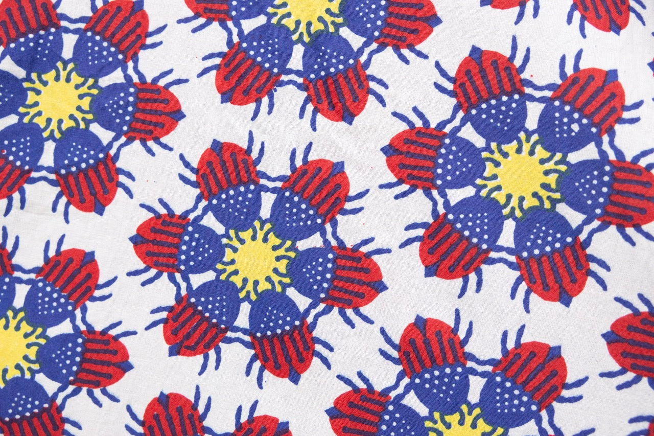 Close up display of dress with yellow, red and blue bug print.