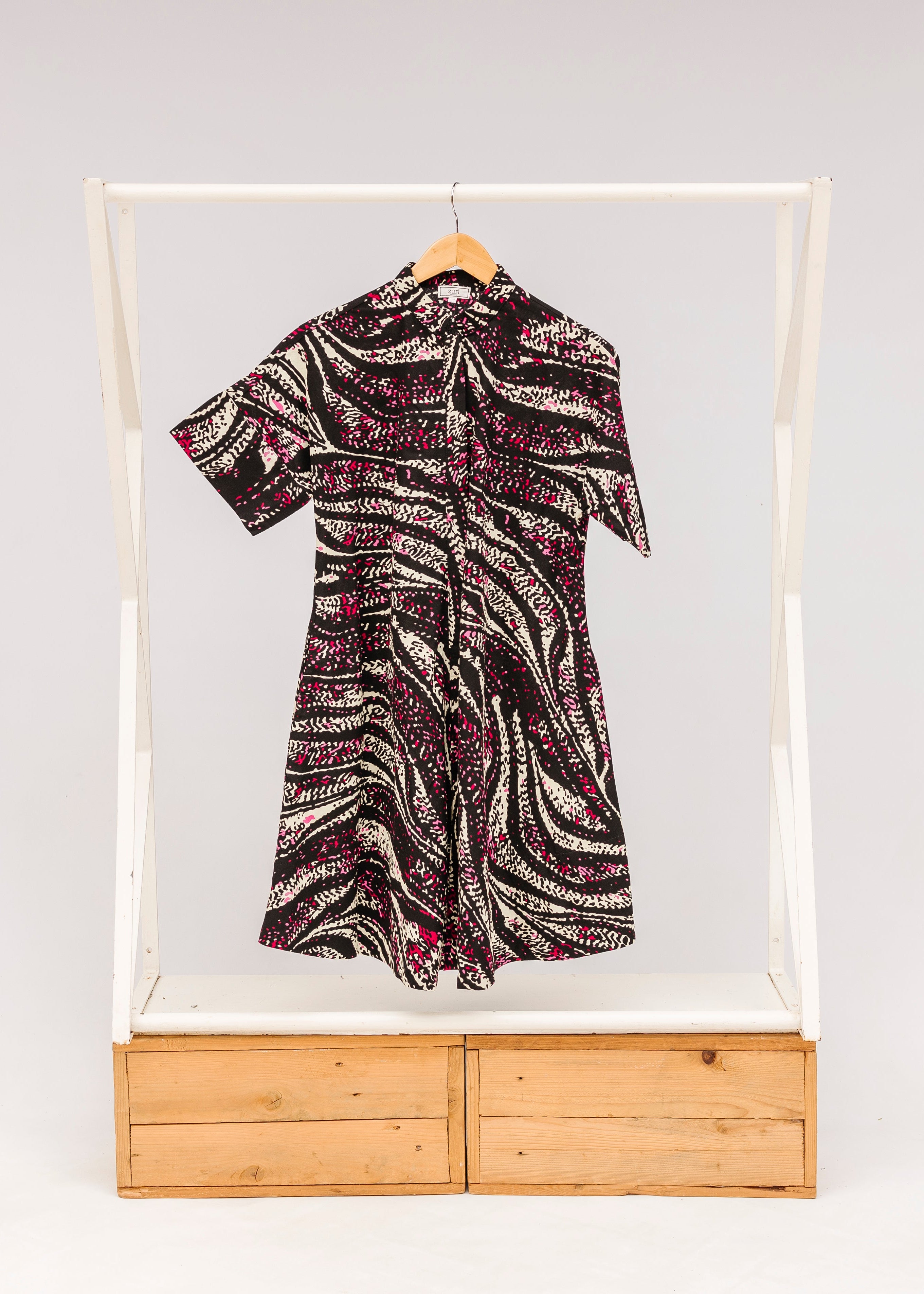 Display of pink, black and white glitter print dress.