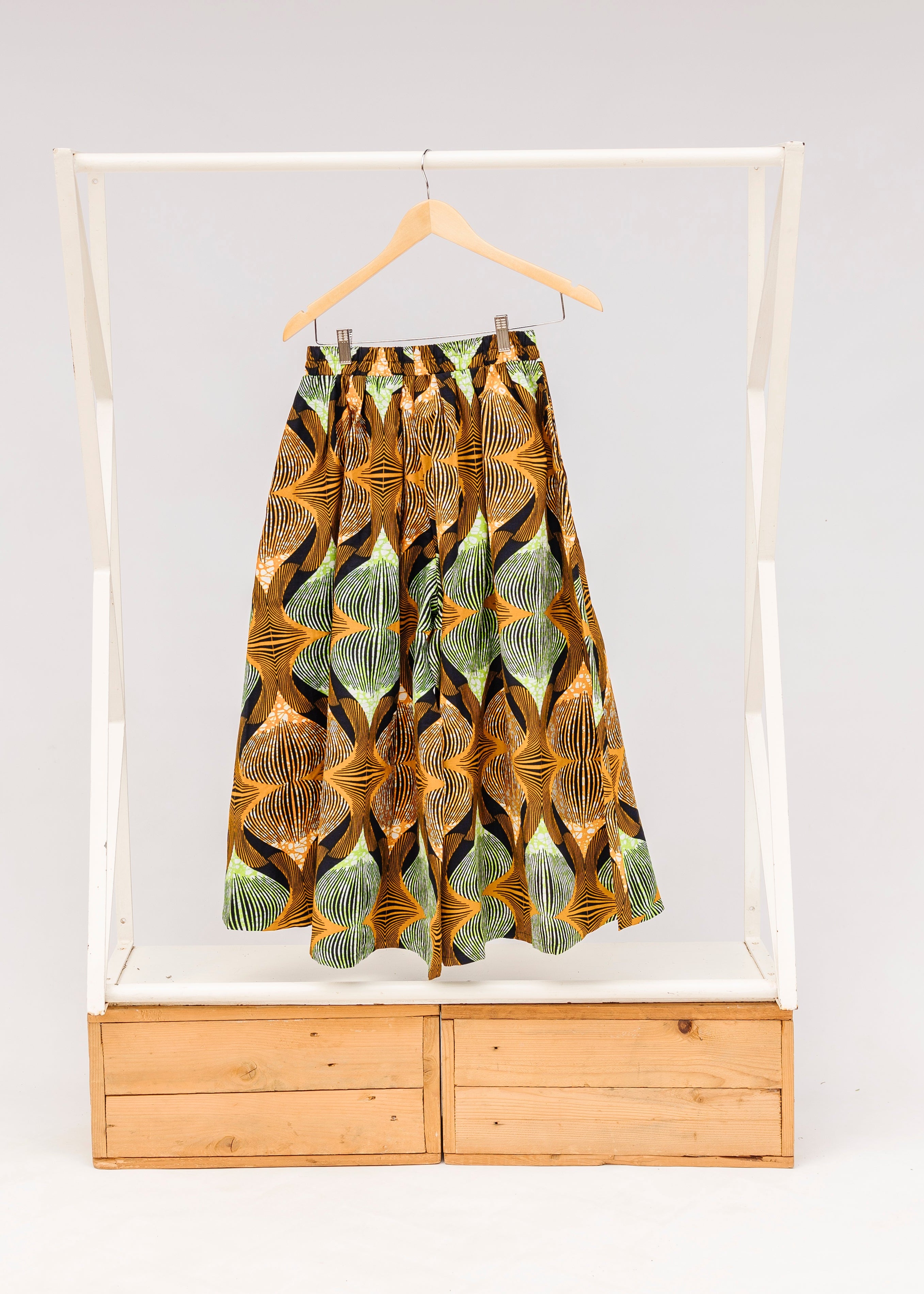 Display of orange and green geometric print pants.