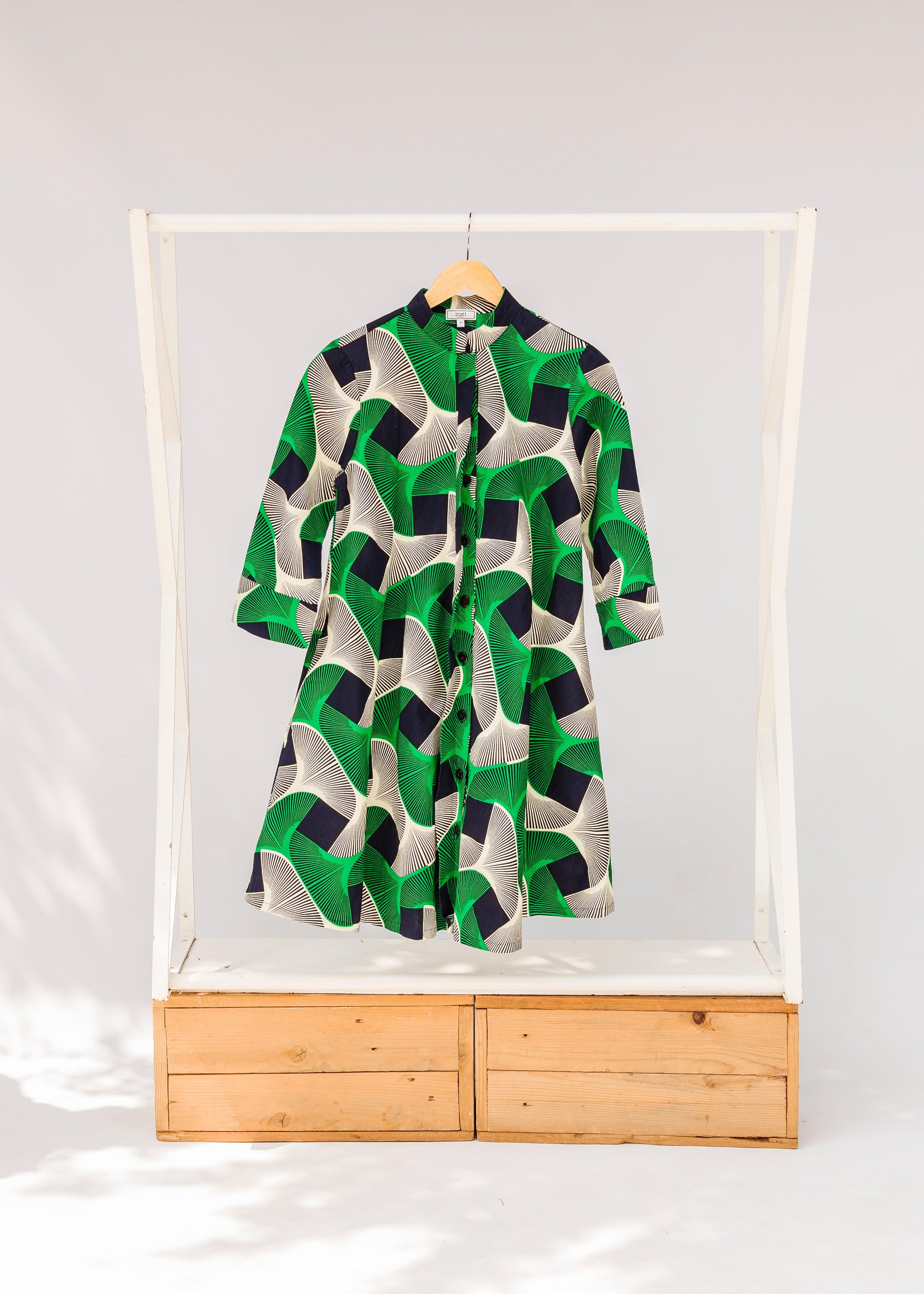 Display of green, black and white abstract print dress. 