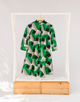 Display of green, black and white abstract print dress. 