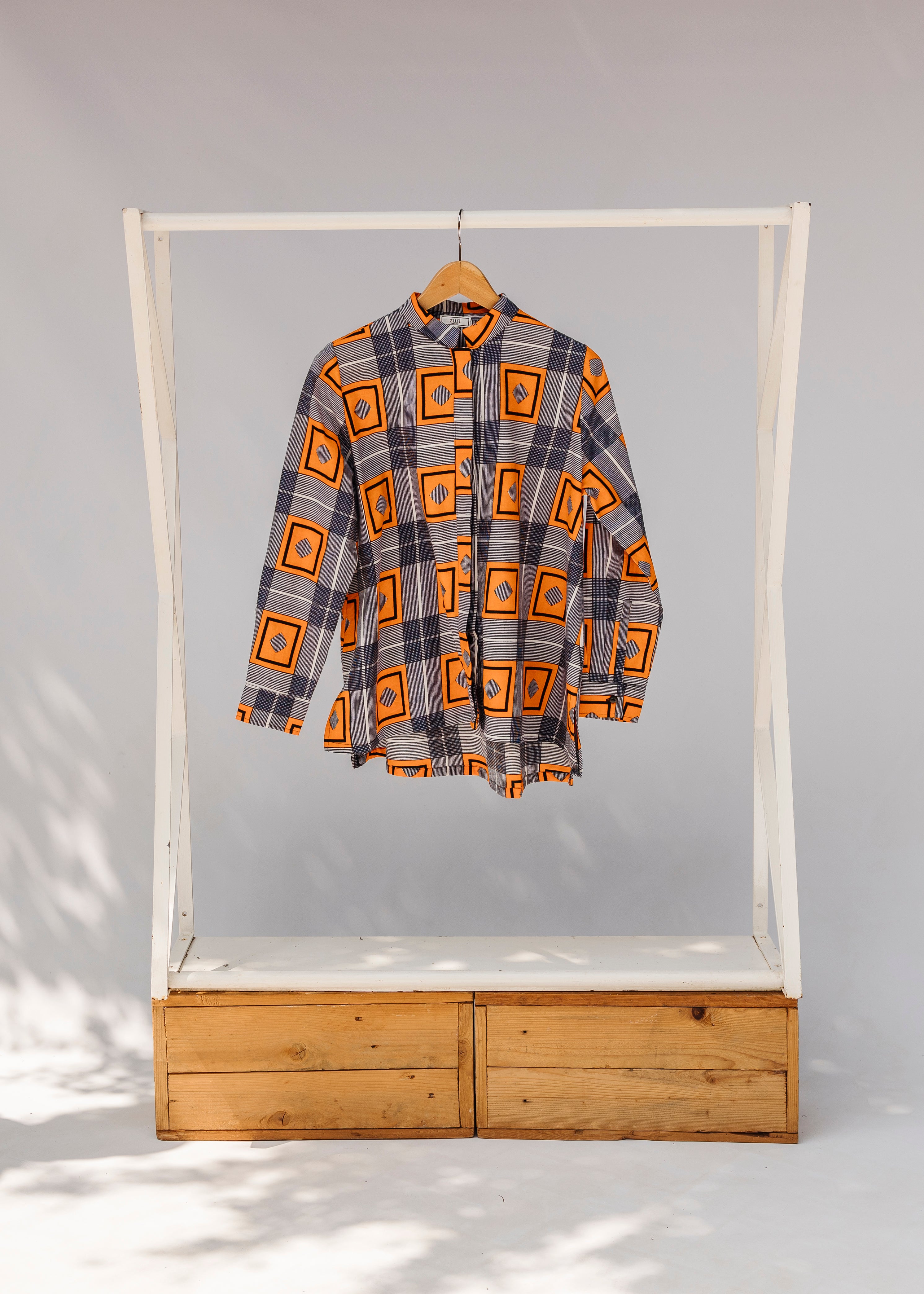 Display of orange, navy and white geometric print shirt.