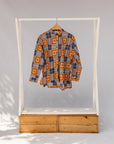 Display of orange, navy and white geometric print shirt.