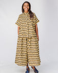 Model wearing mustard and black triangle print pants and shirt.