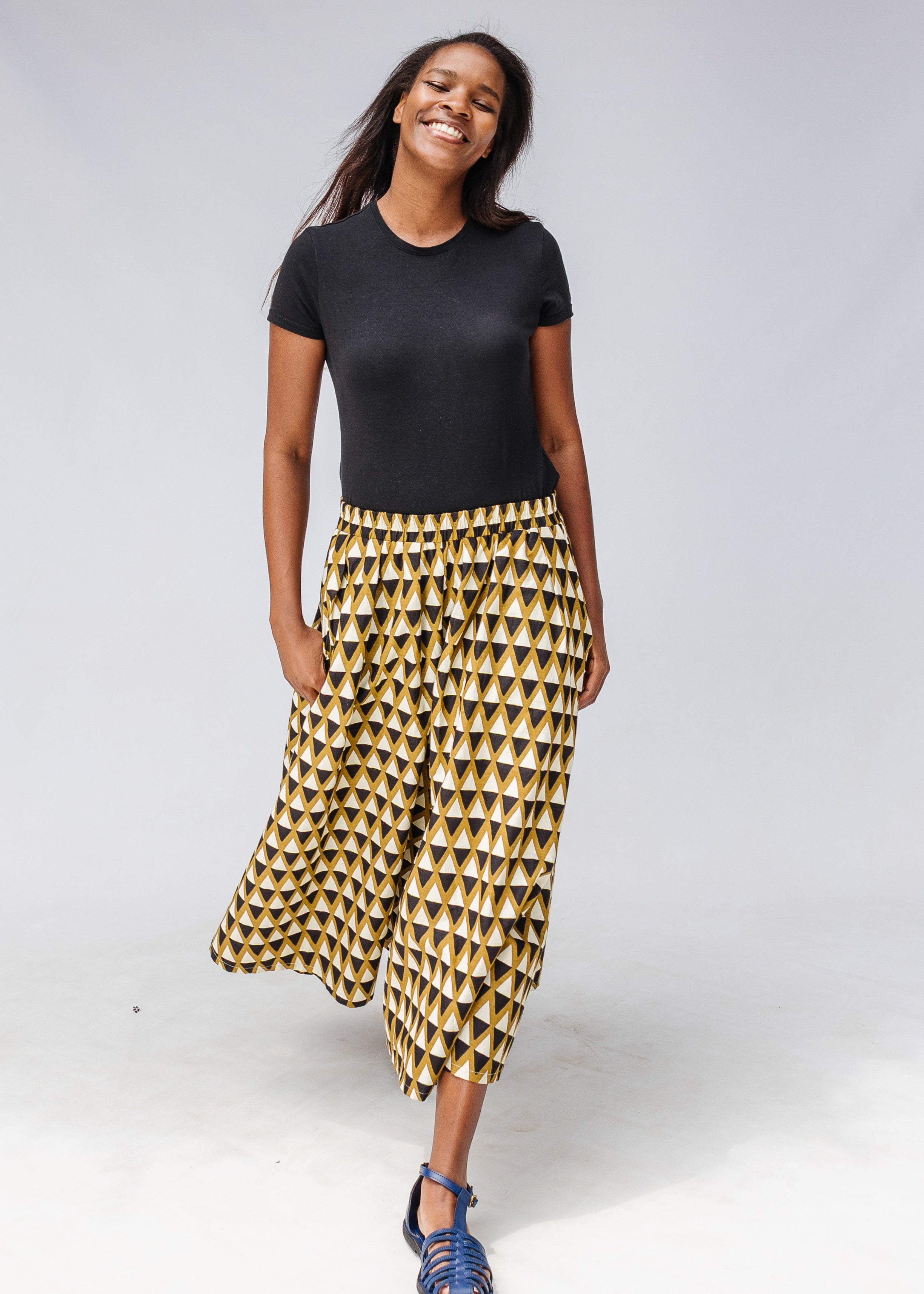 Model wearing mustard and black triangle print pants.