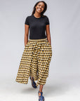 Model wearing mustard and black triangle print pants.