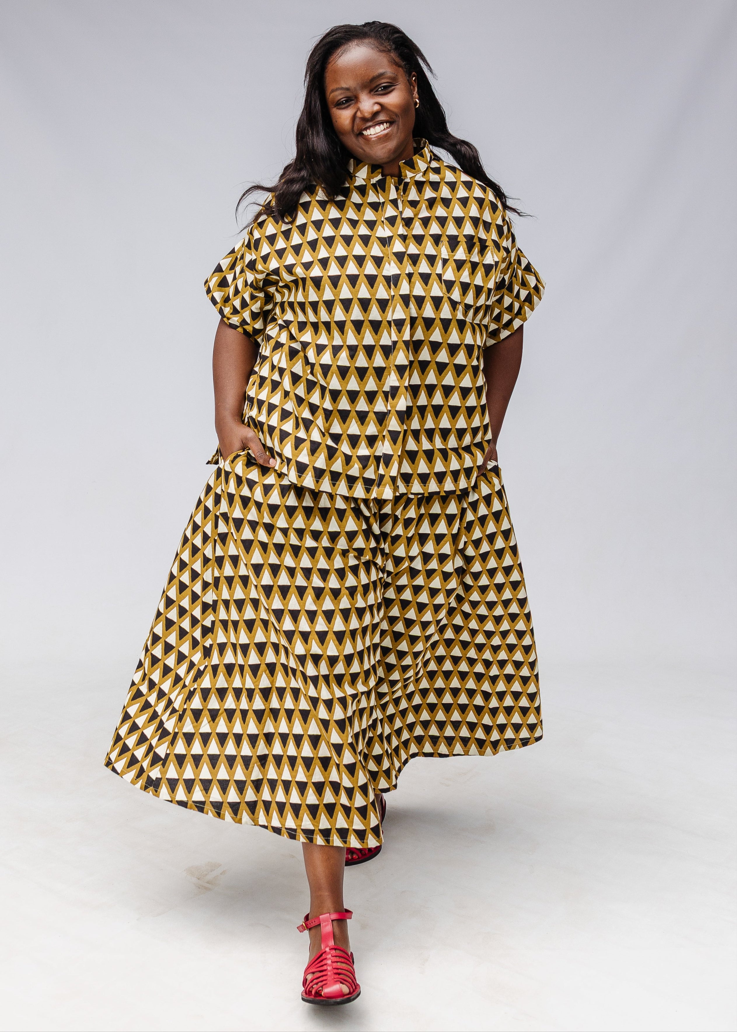 Model wearing mustard and black triangle print pants and shirt.