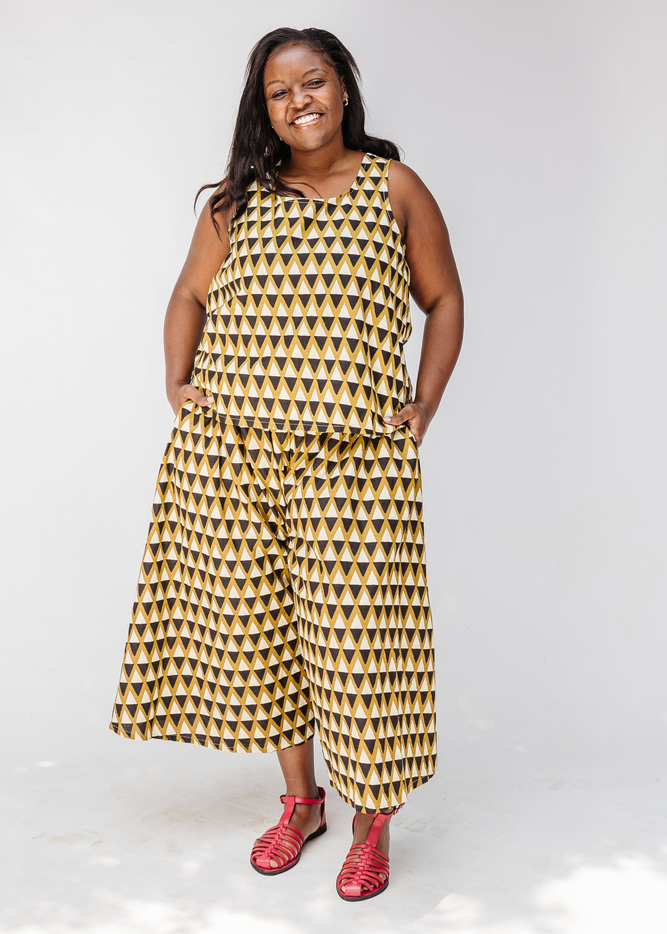 Model wearing mustard and black triangle print pants and tank.